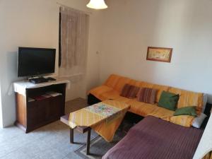 sala de estar con sofá y TV de pantalla plana en Holiday Home Tomislav en Komiža