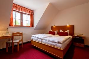 a bedroom with a bed and a desk and a window at Hotel & Restaurant Lengefelder Warte in Anrode