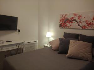 a living room with a bed with a tv on the wall at TINY ROOM in Sassari