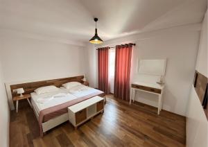 um quarto com uma cama, uma mesa e um espelho em Aquamarine Apartments em Saranda