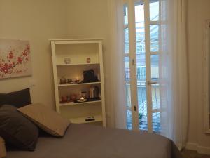 a bedroom with a bed and a door to a balcony at TINY ROOM in Sassari