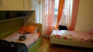 um pequeno quarto com 2 camas e uma janela em Cara Revello em Milão
