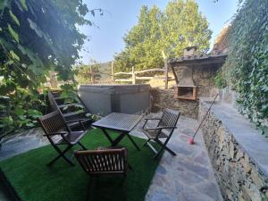 a patio with chairs and a table and a fireplace at Talasnal Montanhas de Amor in Lousã