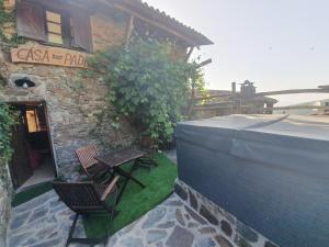 a patio with two chairs and a building at Talasnal Montanhas de Amor in Lousã