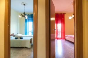 una stanza con un letto e una stanza con tende rosse di Speloncae Apartment a Sperlonga