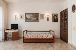 una camera da letto con un letto, una scrivania e una televisione di Speloncae Apartment a Sperlonga