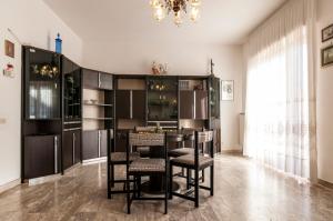 una cucina con tavolo, sedie e lampadario pendente di Speloncae Apartment a Sperlonga