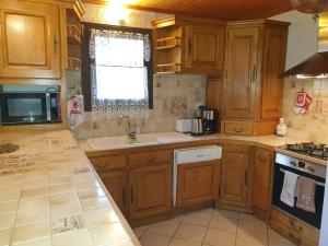 a kitchen with wooden cabinets and a sink and a window at CHALET ALISTELLE - 10 à 12 personnes - TIGNES LES BREVIERES in Tignes