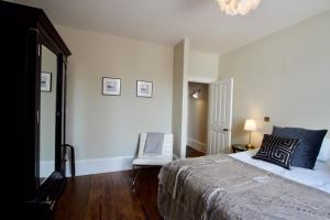 um quarto com uma cama grande e uma cadeira em Old Bank Apartments em Stamford
