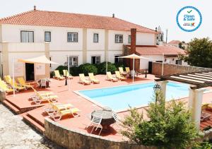 a swimming pool in front of a villa at Casa Da Padeira - Turismo Rural in Alcobaça