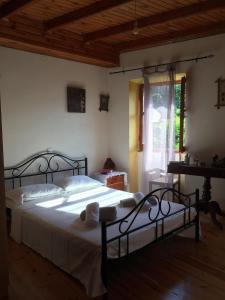 a bedroom with a large bed with white sheets at Country traditional house in Corfu village, Greece in Sinarádes