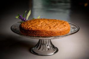 un gâteau assis sur une plaque de verre sur une table dans l'établissement Villa Gelso, à Vesime