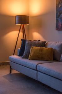 a living room with a couch with a lamp at Liiv Cobogó - Natal Ponta Negra in Natal