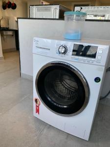 a white washing machine with a container on top of it at Liiv Cobogó - Natal Ponta Negra in Natal