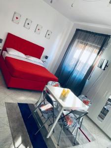 - une chambre avec un lit rouge, une table et des chaises dans l'établissement B&B Adc home, à Ercolano