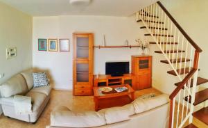 - un salon avec un canapé et un escalier dans l'établissement Apartamentos Brito, à Orzola