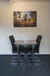 uma mesa e cadeiras com um quadro na parede em Ferienwohnung Downhill am Bocksberg em Hahnenklee-Bockswiese
