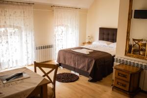 1 dormitorio con cama, mesa y espejo en Hotel Przedzamcze, en Działdowo