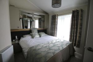 A bed or beds in a room at Grand Eagles Luxury Lodge, Auchterarder
