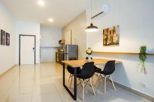 a kitchen and dining room with a wooden table and chairs at Da Men Sunway Subang By ODY Suites in Subang Jaya