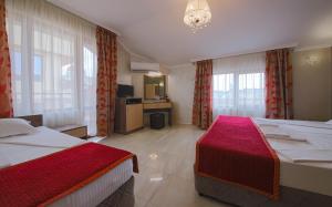 a hotel room with two beds and a television at Guesthouse Phoenix in Obzor