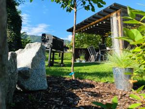 a garden with a bench and a grill at Apartment Nela in Pavčina Lehota