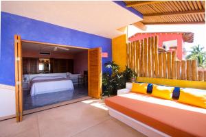 a living room with a couch and a bedroom at Bungalows & Casitas de las Flores in Careyes in Careyes