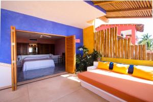 sala de estar con sofá y dormitorio en Bungalows & Casitas de las Flores in Careyes, en Careyes