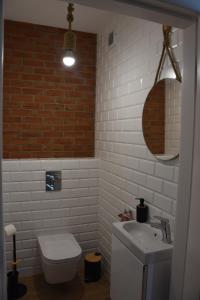 a bathroom with a white toilet and a sink at Klara - Harmonia Oliwska in Gdańsk