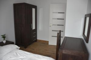 a bedroom with a bed and a dresser and a mirror at Klara - Harmonia Oliwska in Gdańsk