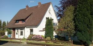 a small white house with a brown roof at Ferienwohnung Schwiemann, Erdgeschoss in Cadenberge