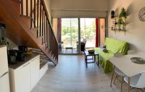 eine Küche und ein Wohnzimmer mit einer Treppe und einem Tisch in der Unterkunft Duplex rénové les pieds dans l'eau in Calvi