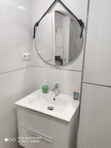 a white bathroom with a sink and a mirror at La Burbuja in Almería