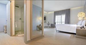 1 dormitorio con espejo grande, 1 cama y baño en Melia Cartagena Karmairi en Cartagena de Indias
