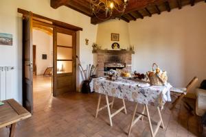 een woonkamer met een tafel en een open haard bij B&B Vallecupa in Farnese