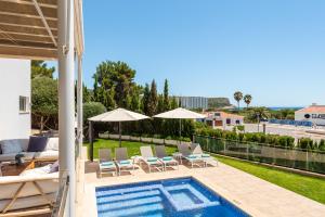 a villa with a swimming pool and patio furniture at Villa Orquidea in Son Bou