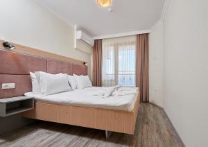 a bedroom with a large bed with white pillows at Crotiria Beach - Aparthotel in Pomorie +37 photos