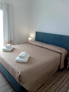 una camera da letto con un letto con due asciugamani sopra di Flamingo Guest House- Rooms a Olbia
