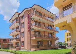 an apartment building with balconies and a sign on it at Guesthouse Phoenix in Obzor