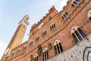 a large brick building with a clock tower at Barbarossa in Siena