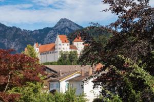 een kasteel op een heuvel met bergen op de achtergrond bij Ferienwohnung Zobl in Füssen
