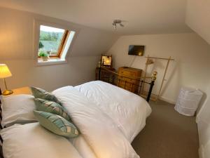 a bedroom with a large white bed with a window at The Rannoch Nest, Kinloch Rannoch in Kinloch Rannoch