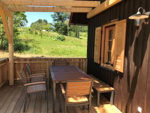 einen Holztisch und Stühle auf der Veranda einer Hütte in der Unterkunft Kellerstöckl Berg 79 in Strem