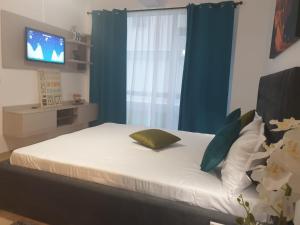 a bedroom with a bed with a window and a television at Body Residence in Mamaia Nord