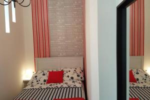 um quarto com um espelho e uma cama com almofadas vermelhas em Cozy Design Downtown Apartment em Budapeste