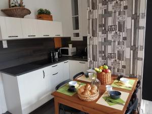 布達佩斯的住宿－Cozy Design Downtown Apartment，厨房配有一张桌子,上面放着一碗水果