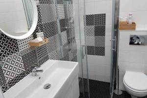 uma casa de banho com um lavatório, um chuveiro e um WC. em Cozy Design Downtown Apartment em Budapeste