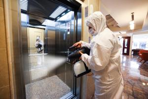 uma pessoa numa cozinha que usa uma máquina para limpar uma porta de vidro em Beddington Residence Sisli em Istambul