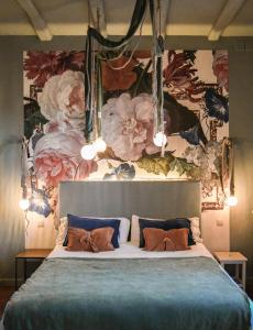 a bedroom with a large bed with a floral wall at Hotel Aiguaclara in Begur