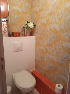 a bathroom with a toilet and a flower on the wall at Figalrance Studio in Plouër-sur-Rance